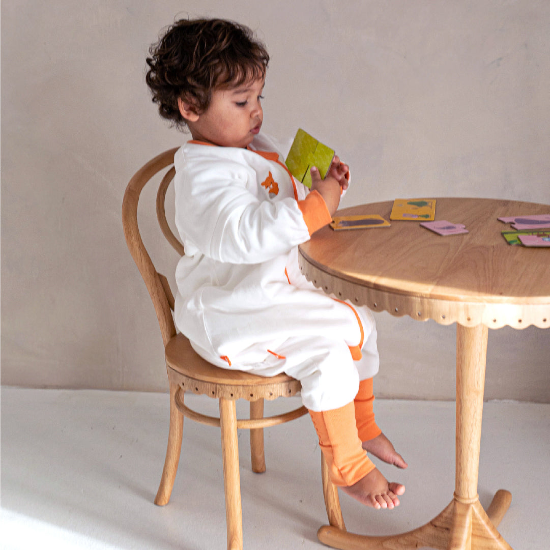 boy play in vosbos play suit with puzzle